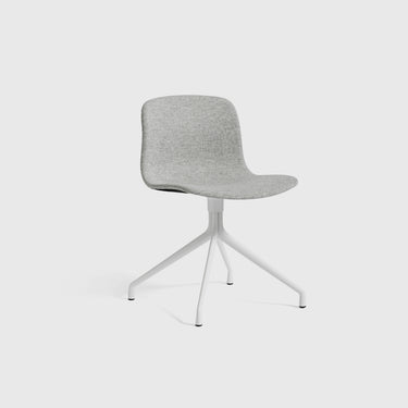 A modern chair with a gray upholstered seat and a white swivel base, designed by Hay.