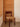 Wooden chair with woven seat against a wooden panel door.