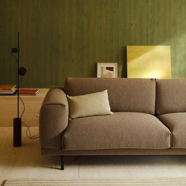 Interior image of a 3.5 seater rest sofa upholstered in taupe boucle fabric in a warmly lit room.