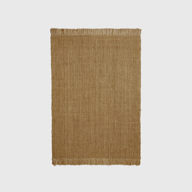 A rectangular, natural color jute rug with a textured weave and a soft fringe.