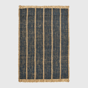 A rectangular woven rug with dark navy blue vertical stripes and natural tan fringed edges, shown flat against a light gray background.