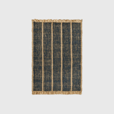 A rectangular woven rug with vertical navy blue stripes and a natural tan jute border and fringe, shown flat against a light gray background.