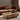 Interior image of a burl coffee table with a brown sofa in a interior living space.