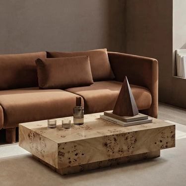 Interior image of a burl coffee table with a brown sofa in a interior living space.