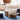 Interior coffee table in a living setting with a sofa, rug and rattan pendant.