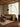 A modern living room featuring a textured beige fabric sofa, a tall black arched floor lamp, a shag rug, and a wood ceiling.