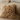 Fluffy beige pillow on a couch with books in the background