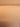 Close-up of a ribbed, pleated material in a warm peach-beige tone, showing vertical folds and a soft gradient from light to darker peach.