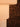 A close-up of a ribbed, warm-toned lampshade or light fixture against a dark brown leopard-print background.