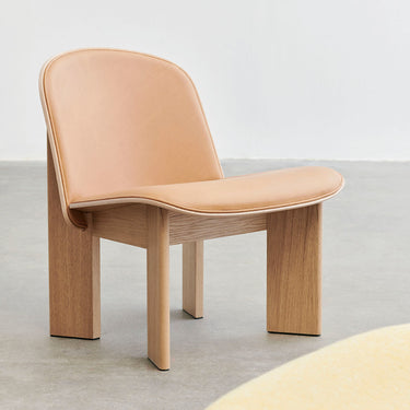 A contemporary upholstered lounge chair with a wooden frame and beige fabric seat, designed by Norwegian designer Andreas Bergsaker.