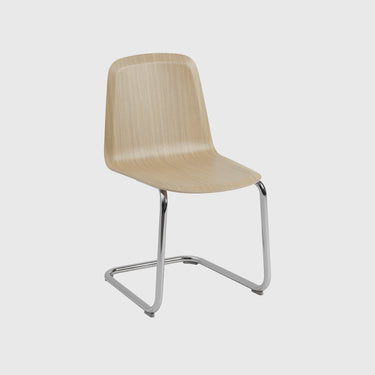 A modern dining chair with a light beige wood-grain molded seat and a chrome cantilever base, shown against a solid light gray background.