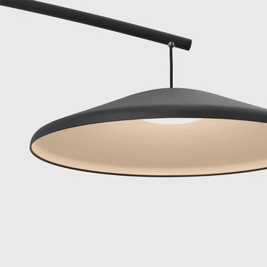 Modern pendant light with a matte black metal frame and a warm cream-colored diffuser, suspended from a black curved arm against a white background.