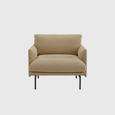 A modern low-profile armchair upholstered in a textured beige fabric, featuring a high backrest, wide armrests, and slim black metal legs, shown against a solid light gray background.