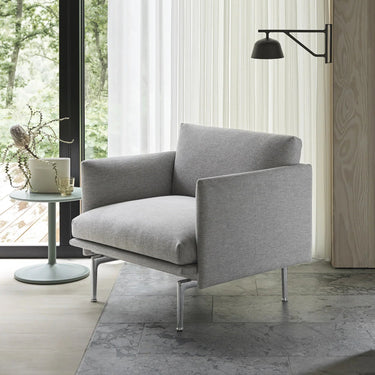 Interior image of a grey textured armchair next to a bright window.
