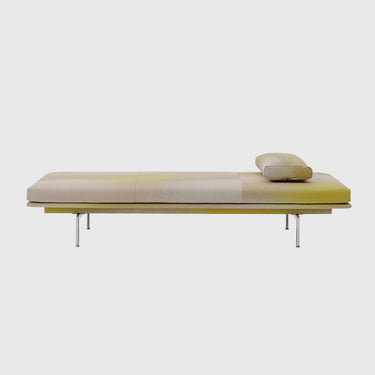 A modern low-profile daybed or chaise lounge with a segmented cream and pale yellow upholstered cushion, supported by a slim metallic frame with thin legs, shown against a plain light gray background.