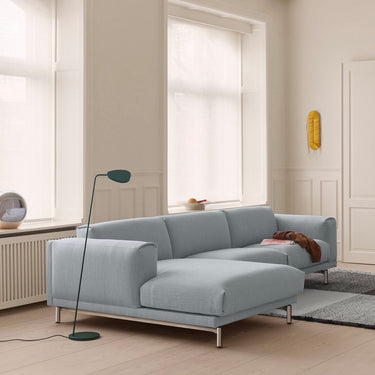 Modern light blue sofa in a bright living room with large windows.