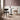 Interior image of 2 chairs and a slim table in the middle of a well lit room.
