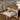 Close up detail of a coffee table on a shaggy rug, sofa in background with books and a vase on the table.