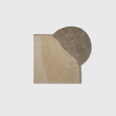 A beige and earth-toned tufted rug with a geometric mountain ridges and dunes design, made from New Zealand wool.