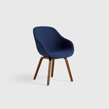A blue upholstered AAC 123 chair with a wooden frame and tapered legs.