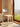 Chair with woven seat and metal frame in a room with a large window showing a view of greenery.