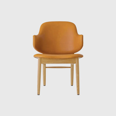 A modern armchair with a curved mustard-yellow leather seat and backrest, supported by a light natural oak wood frame and four legs, shown against a solid light grey background.