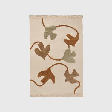 Beige rug with brown and green leaf pattern on a light gray background