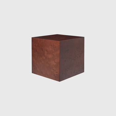 A square metal cube side table or pedestal with a textured, hammered finish in a warm reddish-brown copper color, shown on a solid light gray background.