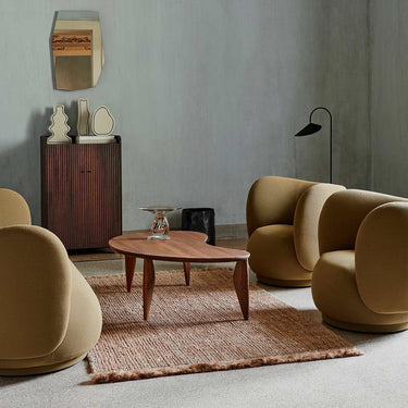 Interior image with a rug, sofa, two lounge chairs and a coffee table in a well lit room.
