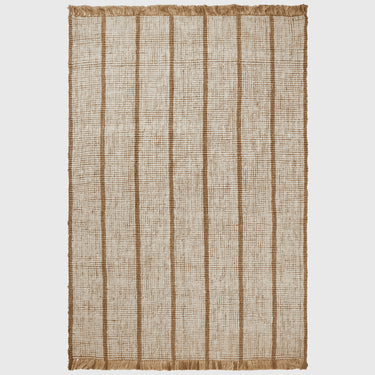 A rectangular woven rug with vertical tan stripes on a natural beige background, finished with fringed edges on all sides, shown flat against a light gray background.