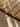 Close-up of a textured brown rug with a checkered pattern on a light-colored floor.