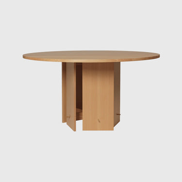 A round dining table made of oiled solid Douglas fir with a flat-packed construction and a brass hooks base, veneer with MDF core.