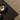 Metallic bowl on a dark wooden surface with a textured beige carpet background
