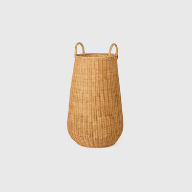 Rattan braided laundry basket on light grey background.