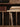 Close-up of a rustic wooden shelving unit with cubby dividers, holding stacked books, a brown box, and a vertical row of vinyl records.