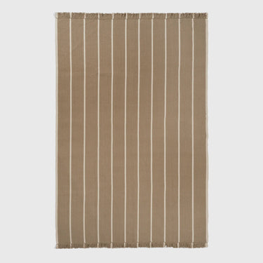 A rectangular woven rug with a warm taupe-brown base and vertical off-white stripes, finished with fringed edges on all sides, shown against a light gray background.