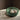 A handmade ceramic centrepiece in emerald green color, displayed on a table with some spherical objects inside it, possibly a fruit or bread basket.