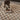 Interior image of checkered jute rug in a living space with a dark wooden stool.