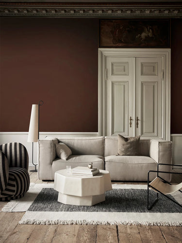 Living room with a beige sofa, round coffee table, and striped armchair.