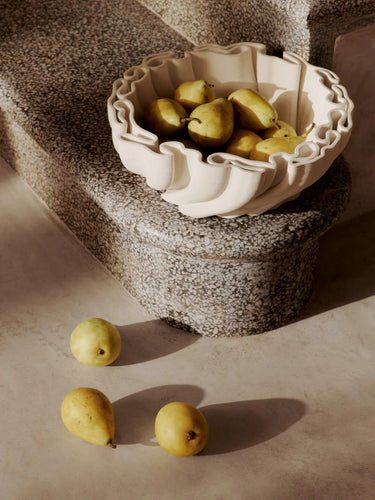 Decorative ceramic bowl with pears on a textured surface