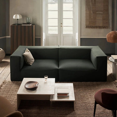 Interior image of a living room with a sofa, coffee table and rug.