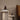 Interior image of a travertine side table with books and sculptures on.
