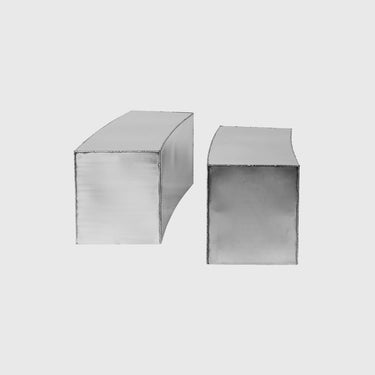 Two rectangular metallic blocks with curved top edges, shown on a plain light gray background.