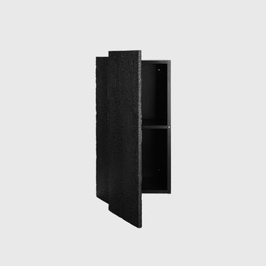 A black textured wall-mounted cabinet with one door open, showing a two-shelf interior, set against a solid light gray background.