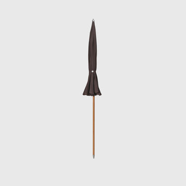 Black patio umbrella with wooden handle on a light gray background
