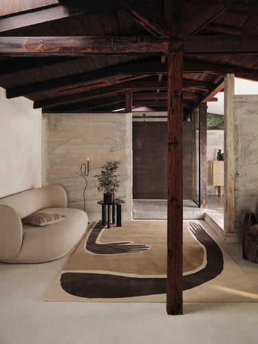Modern interior with a unique rug featuring abstract design, a sofa, and a candle.