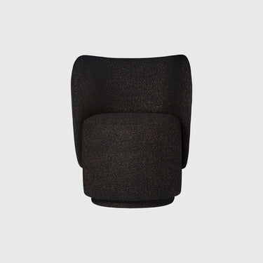 A modern barrel-style armchair upholstered in a textured black fabric with subtle warm gold speckles, shown from the front against a light gray background.