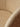 Close-up of a woven fabric upholstered curved surface in a warm beige/tan color, showing the texture and stitching detail.