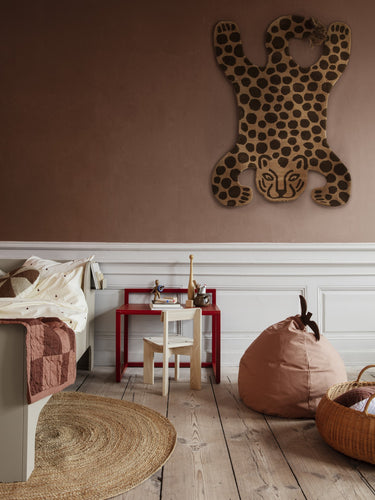 Children's room with a leopard wall decoration, bean bag, and wooden floor.