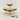 Four glass dessert bowls with striped dessert on a light surface with two spoons.